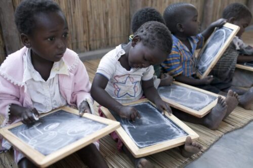 MACHALUCUANE, MOZAMBIQUE - JULY 15:  Children write on chalkboards during a class in the primary school on July 15, 2009, in Machalucuane, Mozambique. The village is located about 18 miles outside Xai-Xai, in Gaza province in Mozambique. The villagers have about 7 miles to the nearest hospital and secondary school. (Photo by Per-Anders Pettersson/Reportage by Getty Images for Save The Children USA)